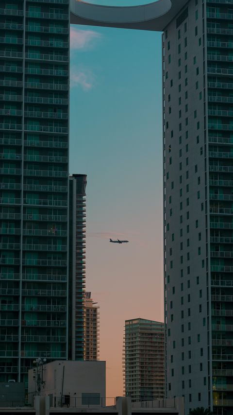 Download wallpaper 2160x3840 airplane, buildings, skyscrapers, evening samsung galaxy s4, s5, note, sony xperia z, z1, z2, z3, htc one, lenovo vibe hd background